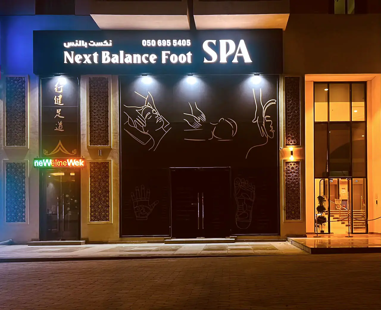 The Next Balance Foot Spa shopfront in Al Jaddaf, Dubai, lit at night